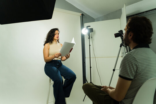 Female talent reading script during casting call, filming an audition with a producer or director in studio