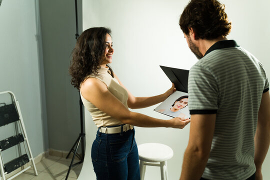 Young actress showing portfolio headshot to male producer during an audition or casting session