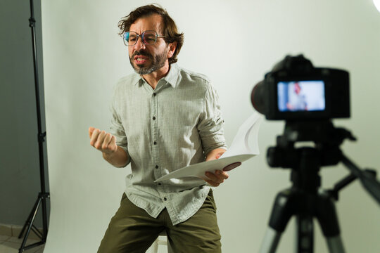 Male actor doing a dramatic performance for a camera at an acting audition, holding a script in a film studio