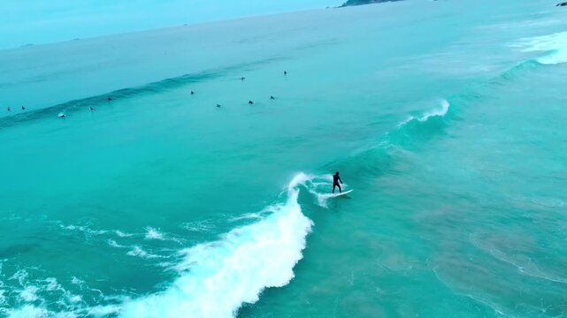 白波が綺麗で波にのるサーファーを早朝に空撮 4K