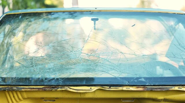 Shattered car windshield showing spiderweb pattern of damage from an accident