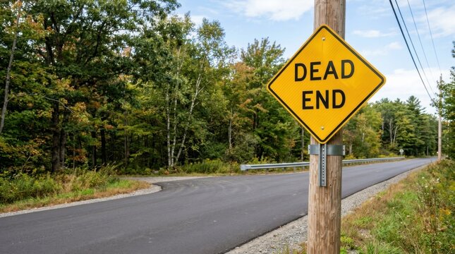 Yellow Diamond Dead End Sign Against Trees And Blue Sky