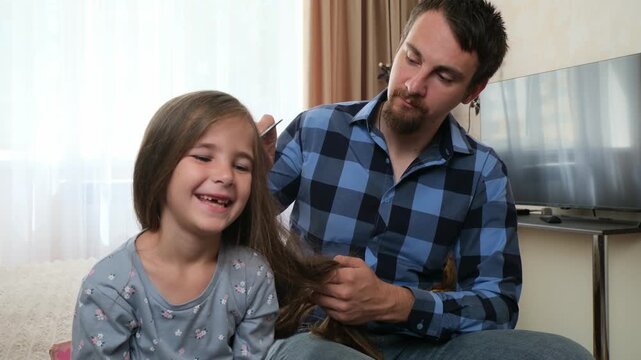 Father dries daughter's hair at home, care guiding every gentle movement. Care creates trust and warmth, while care presents authentic fatherhood, family bonding, and supportive parenting.