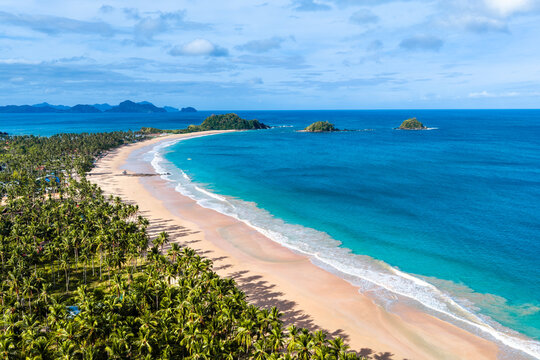 Aerial view of Nacpan beach with perfect sand and palm trees on the island of Palawan in the Philippines 