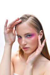 Fototapeta premium A beautiful girl with long blonde hair in profile. Pink and purple blush on her cheeks. Blue and purple eyeshadow on her eyelids.