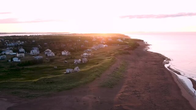 Coastal village and red sand beach on Prince Edward Island at sunrise, Canada, aerial view