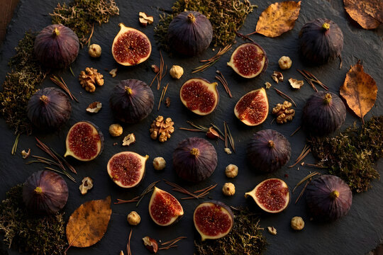 fichi viola e noci su ardesia e foglie d'autunno