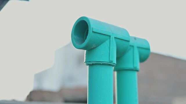 Close Up of Green PVC Pipe Tee Connectors for Water Supply Plumbing System