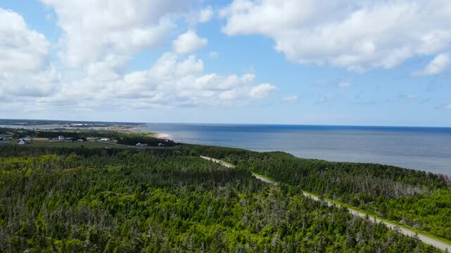 Aerial view of scenic coastal highway through green forest near Thunder Cove Beach, PEI, Canada