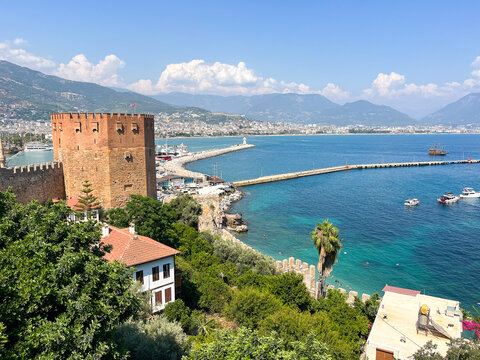 Scenic panoramic view of the historic Red Tower Kizil Kule in Alanya, Turkey, overlooking the blue Mediterranean Sea bay, harbor, and mountains. July 05, 2026