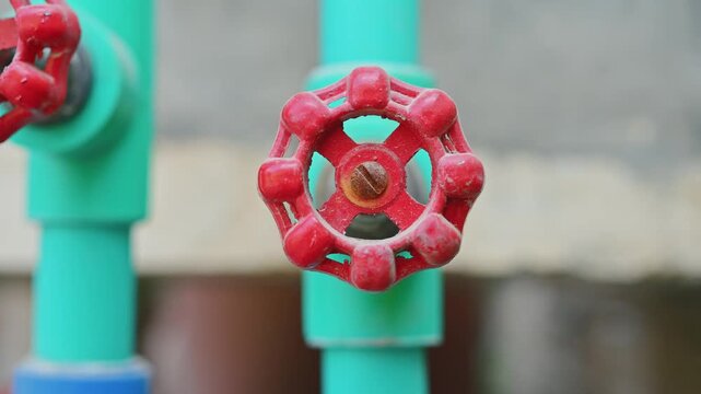 Close Up of Red Valve Handle on Green PVC Water Supply Pipe