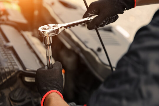 Car care maintenance servicing technician or auto mechanic holding wrench for fix service repairing change spare part engine problem or insurance support or range of car check or training workshop.