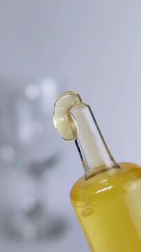 Yellow honey cream emerges from transparent tool tip in extreme close up. Natural skincare moisturizer and cosmetic product texture concept for beauty.