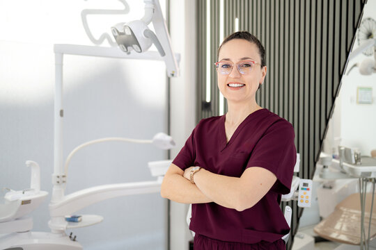 Dental professional smiles in modern clinic during working hours