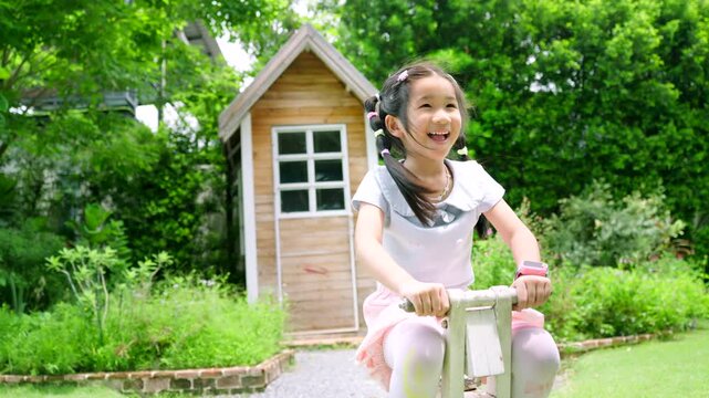 Happy Asian Child Playing Outdoors with Caring Female Guardian in Green Garden, Family Bonding and Childhood Lifestyle Concept Under Natural Sunlight