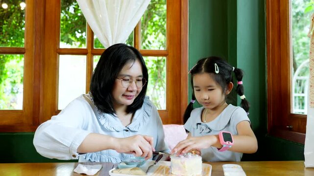 Asian Child Decorating Cake with Caring Parent at Home, Family Bonding and Quality Time During Creative Indoor Activity