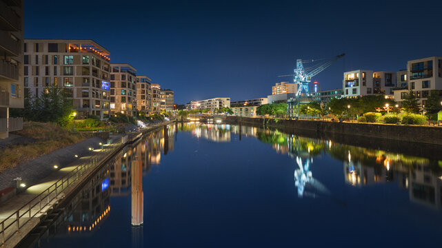 Modern new build properties by the water in Offenbach am Main harbor bey night, Hesse: Development of a new residential area in a city with condominiums and apartments
