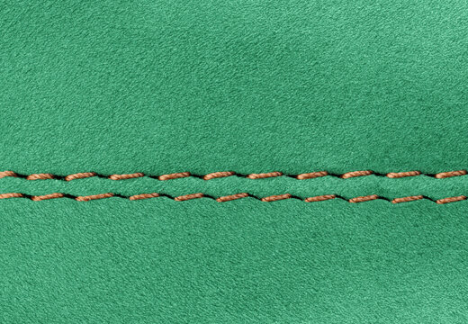 Professional double seam on Green suede leather garment close-up