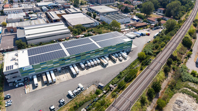 Drone perspective of a large freight warehouse complex Melegnano, Milan, Italy, representing modern logistics infrastructure, cargo handling and European transportation networks.