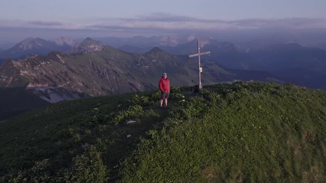 Man on top of a mountain peak at sunset in the Austrian Alps. Achenkirch, Austria