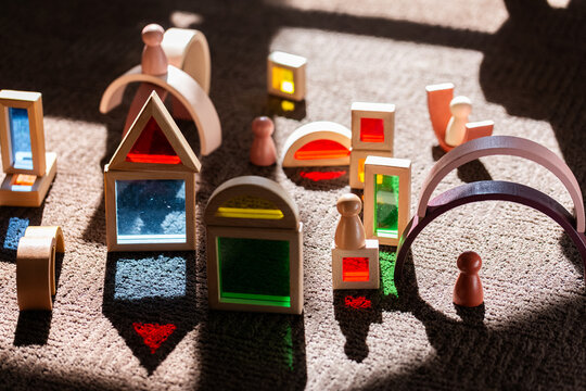 Light shining through colourful toy bocks set up by child on sunlit floor