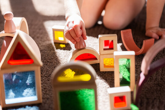 Light shining through colourful toy bocks set up by child on sunlit floor