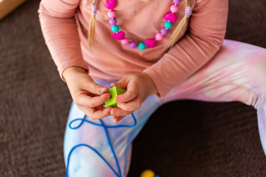 preschooler doing beading threading activity with thread and wood bead