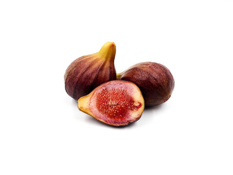 Two fresh and ripe figs and half a fig isolated on a white background.
