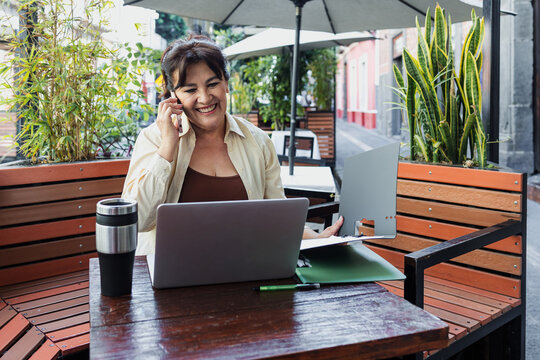 senior latin woman using laptop and having fun outdoors in terrace in Mexico Latin America, mexican female working with computer  