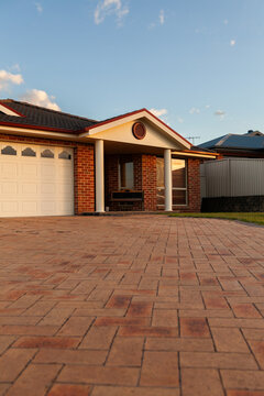 Brick driveway to suburban house in sunset light