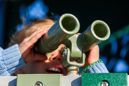 Child playing with binoculars at park playground