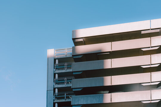 Multi-level concrete parking garage glowing beneath clear blue sky