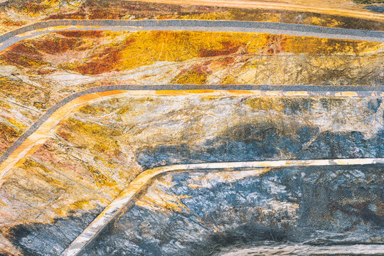 Aerial view of a terraced large open pit mine exposing earth layers