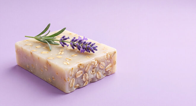 Natural handmade soap bar with lavender and rosemary sprigs on a light purple background with copy space