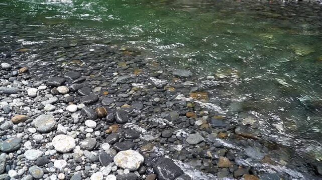 Clear Water of a Mountain River Flowing Gently Over Smooth Colorful Stones and Pebbles on the Bank Rural Nature Background