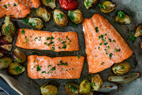 One sheet pan - roasted salmon fillet with vegetables in baking tray. Top view

