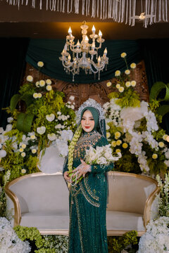 Indonesian Muslim Bride in Emerald Green Payet Gown Holding White Bouquet with Crown