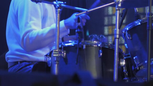Close-up of drummer's hands playing drum kit during live concert