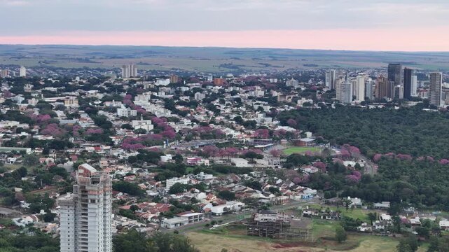 Um v&iacute;deo a&eacute;reo da cidade de Maring&aacute; ao entardecer, panor&acirc;mico, bosques, Parques, Catedral, Centro.