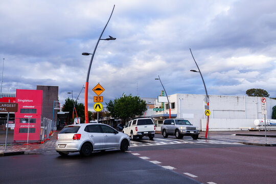 Cars crossing pedestrian crossing speed hump beside intersection