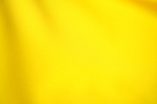 Elegant and beautiful smooth yellow satin fabric surface for illustrations.