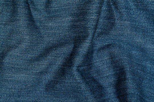 Crumpled dark blue denim fabric texture background