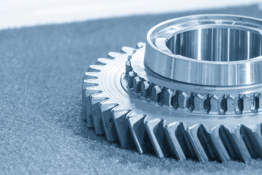 Macro close-up of used transmission bevel gear parts in an industrial blue tone environment.