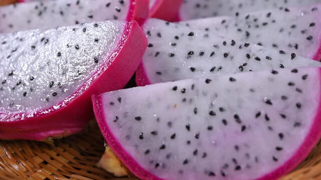 Fresh dragon fruits displayed on a rustic wooden plate, highlighting their vibrant pink skin and natural freshness. A healthy tropical fruit rich in fiber, antioxidants, and vitamin C, perfect for con