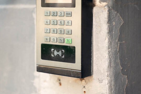 Modern outdoor smart intercom access panel with video camera, PIN keypad, and RFID contactless reader mounted at building entrance.