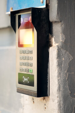 Modern outdoor smart intercom access panel with video camera, PIN keypad, and RFID contactless reader mounted at building entrance.