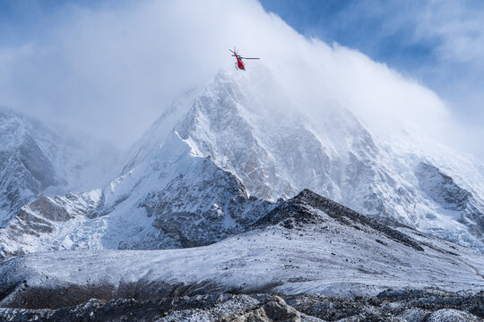 Helicoptero volando entre inmensas monta&ntilde;as en los himalayas
