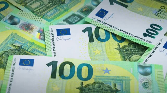 Macro close-up of many 100 euro notes focusing on fine details, security elements and texture, illustrating wealth and cash money concept. 4K Video.