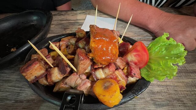 delicious roasted pork meat with plantains and tomato on a plate