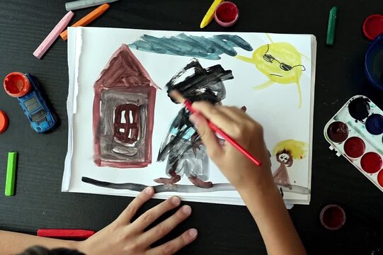a child symbolically covering a frightening figure in a family drawing with black paint. Concept of art therapy, emotional expression, trauma recovery, domestic violence awareness, childhood stress, p